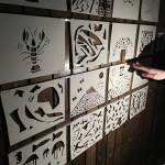 Viele Papiere mit ausgeschnittenen Mustern und Figuren werden angestrahlt.