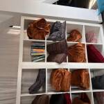 Ein weißes Billy-IKEA Regal in dem unterschiedliche Decken liegen.